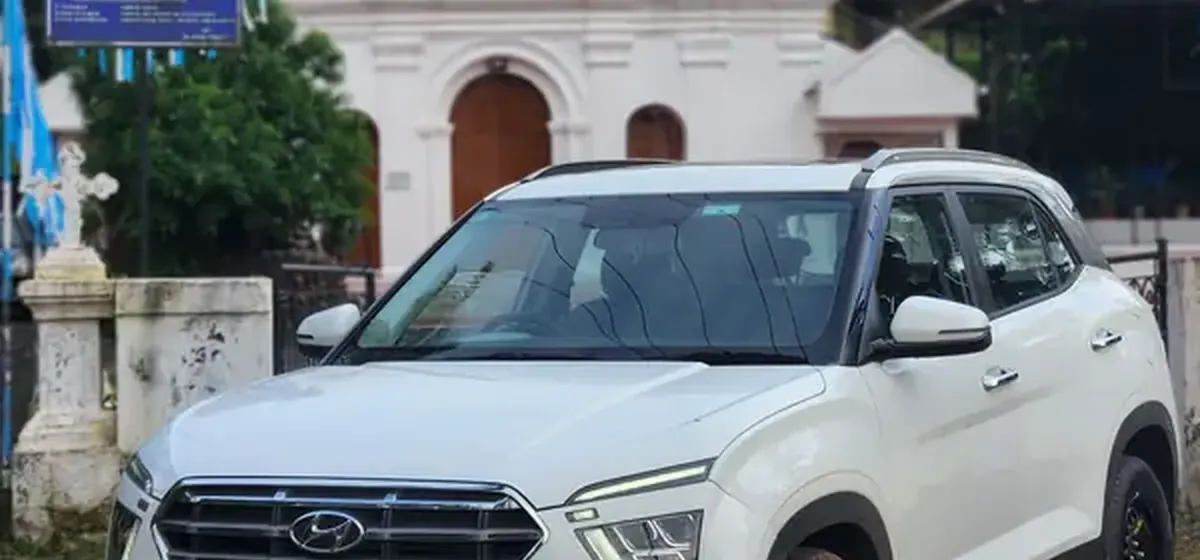 White Hyundai Creta from the Drive Easy fleet outside a whitewashed Goan church